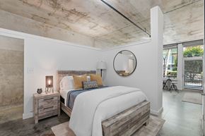 Atlanta apartment for rent - A bedroom with a large bed and a round mirror on the wall.
