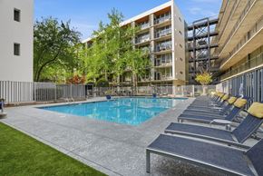 Atlanta apartment for rent - A pool surrounded by lounge chairs and trees.