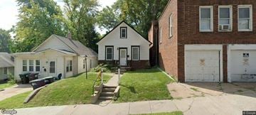 Omaha house for rent - A white house with a black truck parked in front.