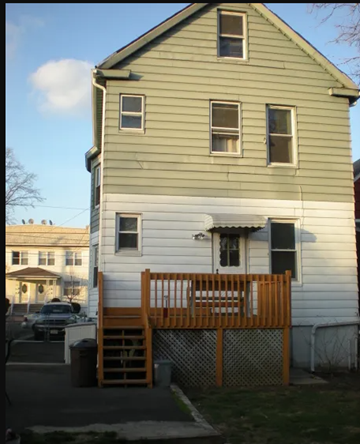 Linden apartment for rent - A two-story house with a white front and a green back.