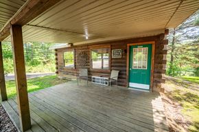 Buchanan house for rent - A wooden porch with a green door and a white window.