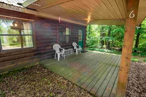 Buchanan apartment for rent - A wooden deck with two chairs and a table is in front of a house.