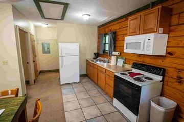 Buchanan apartment for rent - A kitchen with a white fridge, white stove, and a white microwave.