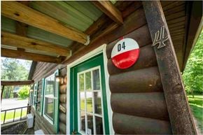 Buchanan apartment for rent - A wooden building with a green door and a sign that says 04.