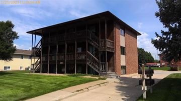 Kearney apartment for rent - A large two-story building with a balcony on the second floor.