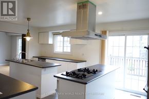 Richmond Hill house for rent - A kitchen with white cabinets and a black stove top.