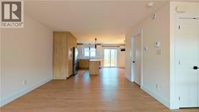 Shediac house for rent - A spacious living room with wooden floors and white walls.