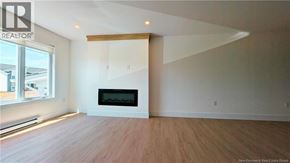 Shediac house for rent - A large, empty room with a fireplace and wooden flooring.