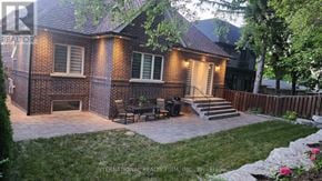 Toronto (Stonegate-Queensway) house for rent - A house with a brick exterior and a patio with a table and chairs.