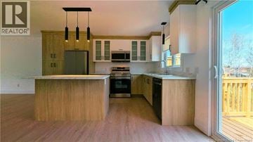 Shediac house for rent - A modern kitchen with wooden cabinets and a large island.