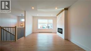 Shediac house for rent - A spacious living room with a staircase on the left and a large window on the right.