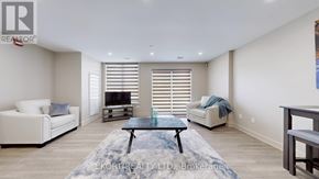 Belleville (Thurlow Ward) house for rent - A living room with a white couch, a coffee table, and a television.