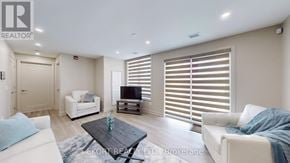 Belleville (Thurlow Ward) house for rent - A living room with a white couch, a coffee table, and a flat screen TV.