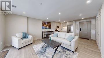 Belleville (Thurlow Ward) house for rent - A living room with a white couch, a coffee table, and a painting on the wall.