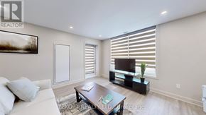 Belleville (Thurlow Ward) house for rent - A living room with a white couch, a coffee table, and a television.