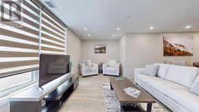 Belleville (Thurlow Ward) house for rent - A living room with a flat screen TV, white sofa, and a coffee table.
