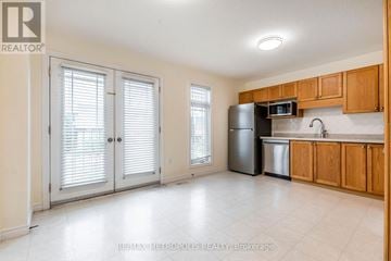 Waterloo townhouse for rent - A kitchen with wooden cabinets and a black refrigerator.