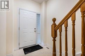 Waterloo townhouse for rent - A white door with a black mat in front of a wooden staircase.