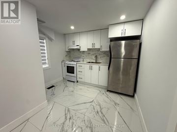 Barrie (Holly) house for rent - A kitchen with white cabinets and a marble floor.