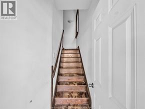 Windsor duplex for rent - A staircase with a white door on the side.