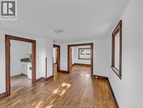 Windsor duplex for rent - A spacious room with wooden floors and white walls.