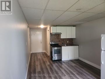 Niagara Falls (Chippawa) house for rent - A kitchen with white cabinets and a stove top oven.