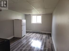 Niagara Falls (Chippawa) house for rent - A white refrigerator in a room with a window and wooden flooring.