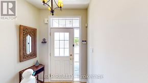 Collingwood townhouse for rent - A hallway with a white door, a mirror, and a chandelier.