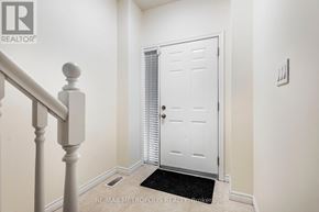 Waterloo townhouse for rent - A white door is in a hallway with a black doormat.
