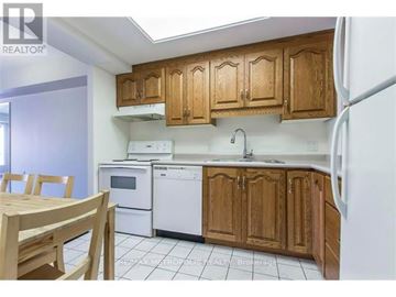 Waterloo condo for rent - A kitchen with wooden cabinets and white appliances.