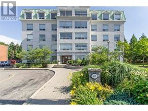 Waterloo condo for rent - A large building with a green roof and a sign that says REALTOR.