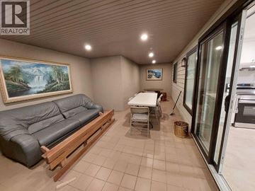 Vancouver house for rent - A living room with a grey couch and a painting of a waterfall on the wall.