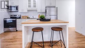 Kitchener condo for rent - A kitchen with a white cabinet and a black stove top oven.