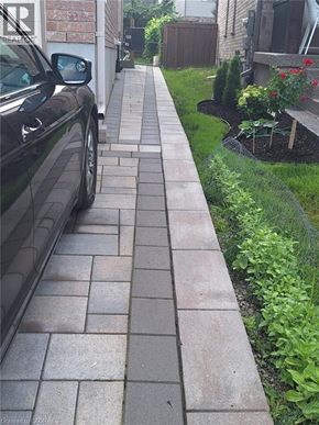 Kitchener house for rent - A black car is parked on a brick sidewalk.