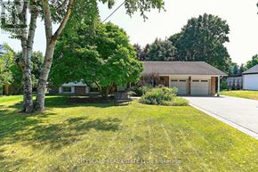 Burlington (Bayview) house for rent - A house with a garage is surrounded by greenery.