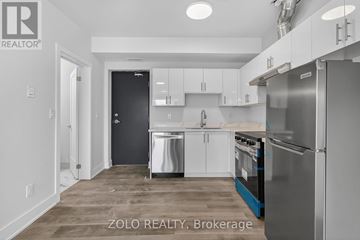 Chatham-Kent (Wallaceburg) multi-family for rent - A kitchen with white cabinets and a black door.