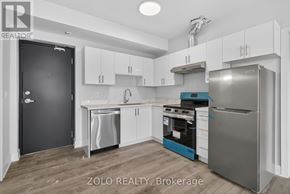 Chatham-Kent (Wallaceburg) multi-family for rent - A kitchen with white cabinets and a black door.