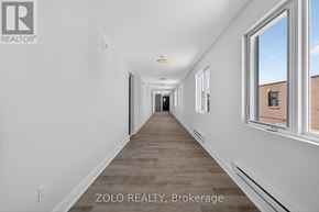 Chatham-Kent (Wallaceburg) multi-family for rent - A long, empty hallway with a window on the right side.