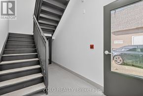 Chatham-Kent (Wallaceburg) multi-family for rent - A staircase in a building with a glass door leading outside.