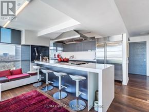 Toronto (Rosedale-Moore Park) condo for rent - A modern kitchen with a bar stool and a red rug.