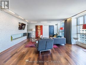 Toronto (Rosedale-Moore Park) condo for rent - A living room with a grey couch and a wooden floor.
