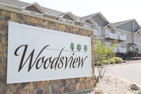 Janesville apartment for rent - A sign that says Woodsview in front of a building.