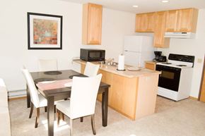 Janesville apartment for rent - A kitchen with a table and chairs and a fridge.