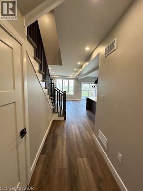 Ingersoll townhouse for rent - A hallway with wood flooring and white walls.
