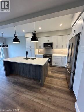 Ingersoll townhouse for rent - A modern kitchen with a large island and stainless steel appliances.