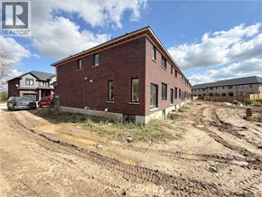 Ingersoll townhouse for rent - A red brick building with a white sign that says REALTOR in the upper left corner.