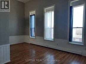 For rent in Prescott - A room with two windows and a wooden floor.
