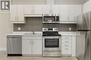 Binbrook apartment for rent - A modern kitchen with stainless steel appliances and white cabinets.