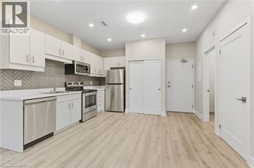 Binbrook apartment for rent - A kitchen with white cabinets and a wooden floor.