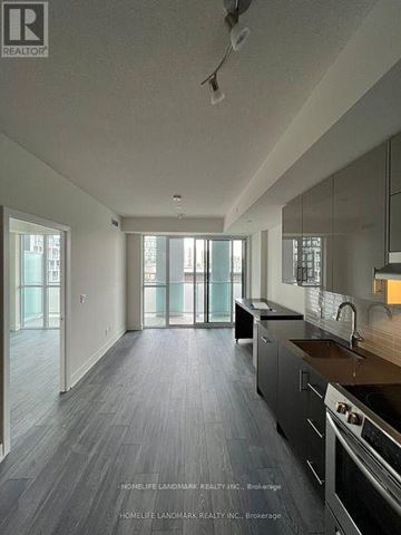 Toronto (Don Valley Village) condo for rent - A modern kitchen with dark wood floors and stainless steel appliances.